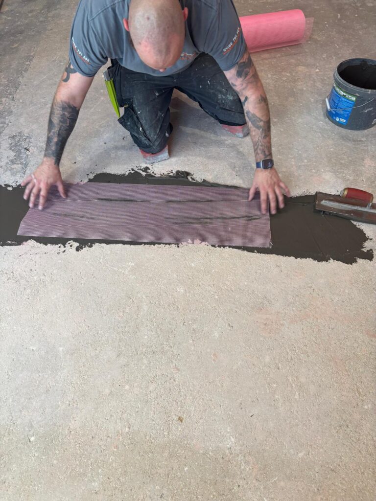 applying smoothing compound in hallway